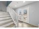 Welcoming entryway featuring light gray walls, tiled floors, a staircase, and a double glass door for ample light at 527 Magnolia Ave, Anna Maria, FL 34216