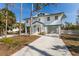 Inviting elevated home featuring a white exterior and a blue roofline, complemented by well-maintained landscaping at 527 Magnolia Ave, Anna Maria, FL 34216