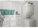 Efficient laundry room with washer, dryer, storage shelves, and a practical ironing setup at 527 Magnolia Ave, Anna Maria, FL 34216