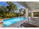 Refreshing pool with lounge chairs and lush tropical landscaping at 527 Magnolia Ave, Anna Maria, FL 34216