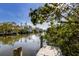 Picturesque waterfront view from private dock; boats and charming homes nestled among lush greenery at 527 Magnolia Ave, Anna Maria, FL 34216