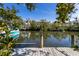 Scenic waterfront view from a private dock, with boats, lush trees, and idyllic neighborhood at 527 Magnolia Ave, Anna Maria, FL 34216
