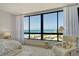 Airy bedroom featuring a large ocean-view window and cozy seating area at 535 Sanctuary Dr # B604, Longboat Key, FL 34228