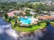 High-angle view of a community pool, lake and clubhouse surrounded by lush landscaping at 573 Misty Pine Dr, Venice, FL 34292