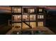 The home's back exterior is illuminated at night, with balconies, outdoor stairs, a patio, and a shimmering swimming pool at 597 Buttonwood Dr, Longboat Key, FL 34228