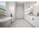 Bright, spacious bathroom with marble floors, double vanity, and a modern freestanding tub at 597 Buttonwood Dr, Longboat Key, FL 34228