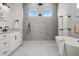 A gorgeous bathroom features marble tile, a soaking tub, and a frameless shower at 597 Buttonwood Dr, Longboat Key, FL 34228