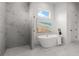 Luxurious bathroom featuring a soaking tub, glass shower, and elegant tile work at 597 Buttonwood Dr, Longboat Key, FL 34228