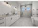 A luxurious bathroom featuring double sinks, sleek white cabinets, and a stunning glass-enclosed shower at 597 Buttonwood Dr, Longboat Key, FL 34228