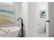 Modern bathroom featuring a sleek freestanding tub with a black faucet and stylish artwork at 597 Buttonwood Dr, Longboat Key, FL 34228