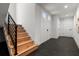 Modern hallway with wood stairs, black steel railing, tiled floor, and white doors adding architectural interest to the home at 597 Buttonwood Dr, Longboat Key, FL 34228