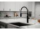 Close-up of a modern kitchen sink with a black faucet and white quartz countertops at 597 Buttonwood Dr, Longboat Key, FL 34228