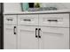 Detailed view of sleek white kitchen cabinets with contemporary black hardware at 597 Buttonwood Dr, Longboat Key, FL 34228