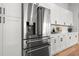 Stainless steel refrigerator with white cabinets and hardwood floors at 597 Buttonwood Dr, Longboat Key, FL 34228