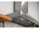 Stainless steel THOR range hood with lights accents the contemporary kitchen design at 597 Buttonwood Dr, Longboat Key, FL 34228