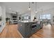 Open-concept kitchen flows to the living room, featuring a gray kitchen island with stainless steel appliances at 597 Buttonwood Dr, Longboat Key, FL 34228