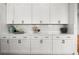 White cabinets, marble countertops and backsplash in the kitchen at 597 Buttonwood Dr, Longboat Key, FL 34228