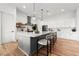 Bright kitchen with a large island, stainless steel appliances, white cabinets, and hardwood floors at 597 Buttonwood Dr, Longboat Key, FL 34228