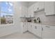 Bright laundry room with white cabinetry, quartz countertops, and a modern black faucet at 597 Buttonwood Dr, Longboat Key, FL 34228