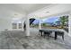 Covered patio with seating area overlooks a sparkling pool and beautifully landscaped backyard at 597 Buttonwood Dr, Longboat Key, FL 34228