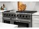 Close-up of a professional-grade stainless steel gas range with multiple burners and knobs, set in a modern kitchen at 597 Buttonwood Dr, Longboat Key, FL 34228