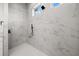 Modern shower with white marble-patterned tile walls and black fixtures, providing a luxurious bathing experience at 597 Buttonwood Dr, Longboat Key, FL 34228