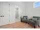 Inviting sitting area with two gray chairs, blue throw pillows, and view of a bathroom at 597 Buttonwood Dr, Longboat Key, FL 34228