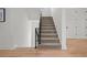 Carpeted staircase with a modern black railing and hardwood flooring on the lower level at 597 Buttonwood Dr, Longboat Key, FL 34228