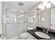 Bathroom featuring a glass shower, black countertop, and white cabinets at 5970 Midnight Pass Rd # 177, Sarasota, FL 34242