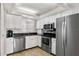 Well-lit kitchen features stainless steel appliances, a large sink, and white cabinetry at 5970 Midnight Pass Rd # 177, Sarasota, FL 34242