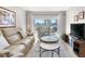 Cozy living room featuring comfortable seating, stylish decor, and access to a private balcony with city views at 5970 Midnight Pass Rd # 177, Sarasota, FL 34242