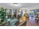 Open-concept dining area with a glass table and views of the living room and golf course beyond at 6120 43Rd W St # 103B, Bradenton, FL 34210