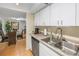 Bright kitchen featuring white cabinets, stainless steel appliances, and an adjacent dining area at 6120 43Rd W St # 103B, Bradenton, FL 34210