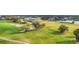Aerial view of a golf course featuring rolling green hills, water features, and surrounding residential area at 6314 Stone River Rd # 6314, Bradenton, FL 34203