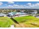 Aerial view of golf course, clubhouse, and surrounding community with a lake, and lush greenery at 6314 Stone River Rd # 6314, Bradenton, FL 34203