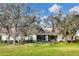 Spacious backyard featuring a well-maintained lawn, mature trees, and sliding glass doors at 6314 Stone River Rd # 6314, Bradenton, FL 34203