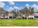 Backyard with green lawn, mature trees, and putting green. Great for relaxation and recreation at 6314 Stone River Rd # 6314, Bradenton, FL 34203