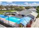 Aerial view of the community pool featuring clear blue water, lounge chairs, and cabanas at 6314 Stone River Rd # 6314, Bradenton, FL 34203