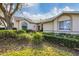 Inviting front exterior featuring arched windows, a decorative front door, and mature landscaping at 6314 Stone River Rd # 6314, Bradenton, FL 34203