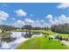 Scenic golf course with a tranquil lake and players on the green at 6314 Stone River Rd # 6314, Bradenton, FL 34203