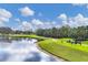 Picturesque golf course featuring a serene lake, lush green fairways and golfers on the course at 6314 Stone River Rd # 6314, Bradenton, FL 34203
