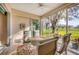 Enclosed lanai featuring a dining table and chairs with a ceiling fan overlooking a beautiful tree at 6314 Stone River Rd # 6314, Bradenton, FL 34203