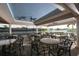 Charming outdoor seating area with tables, chairs, ceiling fans and views of the tennis court and lake at 6314 Stone River Rd # 6314, Bradenton, FL 34203