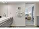 Bathroom featuring gray cabinets, modern fixtures, and bedroom access at 6415 Midnight Pass Rd # 211, Sarasota, FL 34242