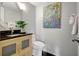 Well-lit half bathroom featuring a vanity with a wood cabinet, modern fixtures, and colorful wall art at 6415 Midnight Pass Rd # 211, Sarasota, FL 34242