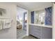 Bathroom vanity with ample storage, decorative mirror, and open view to the main bedroom and blue accented decor at 6415 Midnight Pass Rd # 211, Sarasota, FL 34242