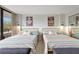 Bright bedroom featuring two beds, colorful decor, and a sliding glass door leading to a private balcony with outdoor views at 6415 Midnight Pass Rd # 211, Sarasota, FL 34242