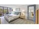 Bright bedroom with a large bed, rug, balcony, and a unique blue-tiled mirror at 6415 Midnight Pass Rd # 211, Sarasota, FL 34242