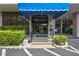 Inviting entrance to the condo building featuring a sheltered awning, landscaped entryway and secure glass doors at 6415 Midnight Pass Rd # 211, Sarasota, FL 34242