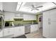 Updated kitchen features sleek white cabinets, stainless steel appliances, modern lighting, and ample counter space at 6415 Midnight Pass Rd # 211, Sarasota, FL 34242